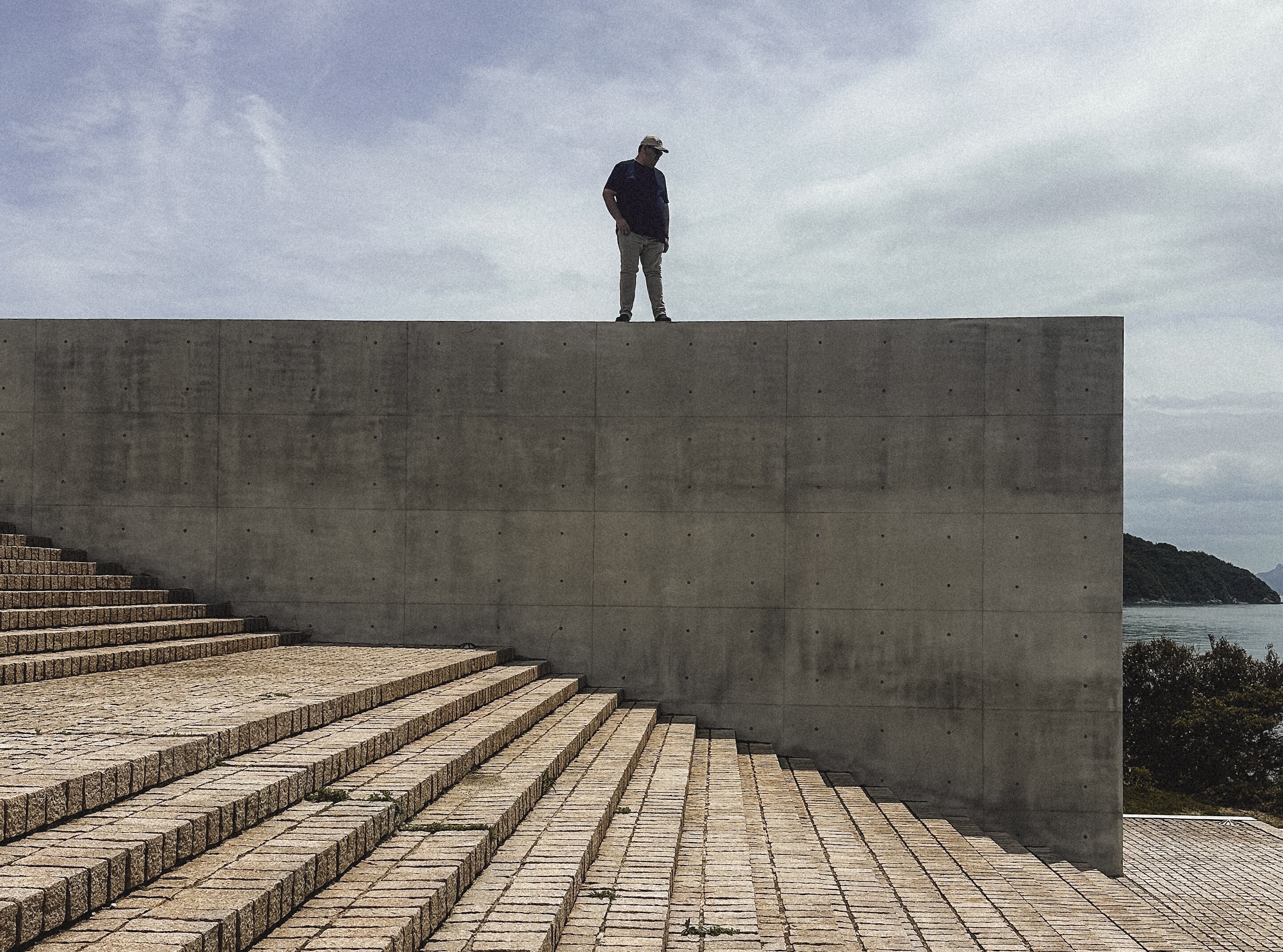 Fernando Rodríguez de pie sobre un muro de concreto frente al mar